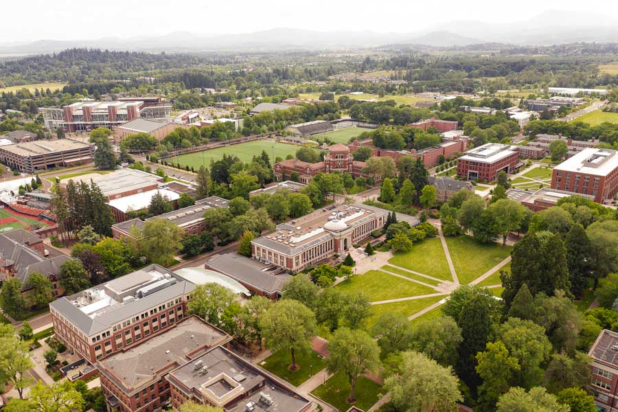 An aerial view of Oregon State Univerisity's Corvalis campus with red brick buildings and many green trees.