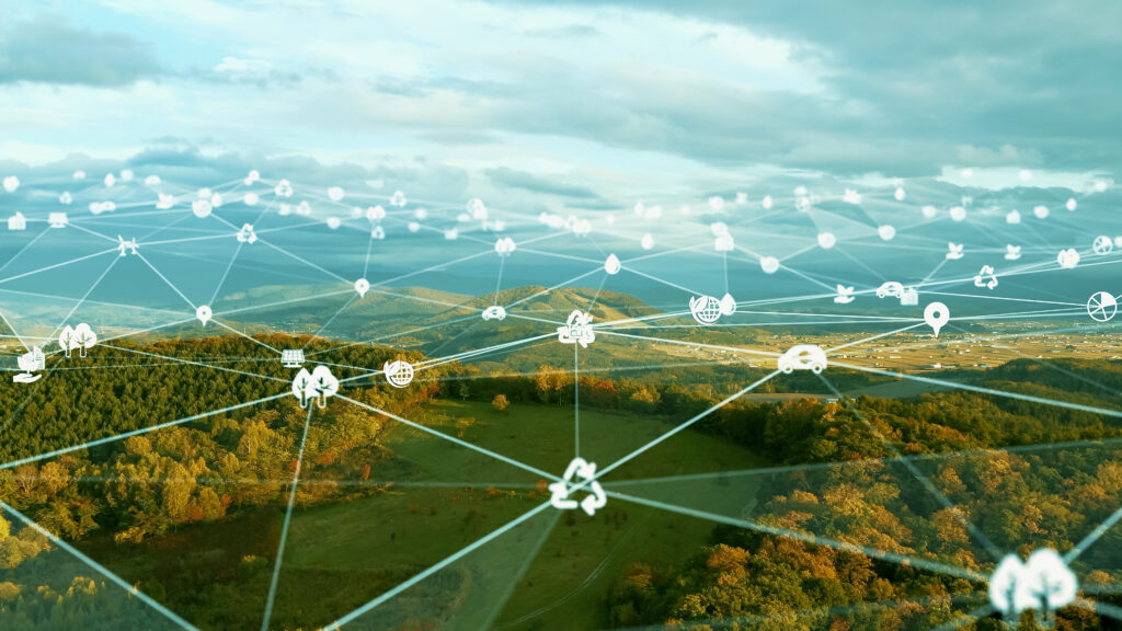 A photo illustration of netowk nodes connected by lines overlaying an aerial photo of a rural landscape.